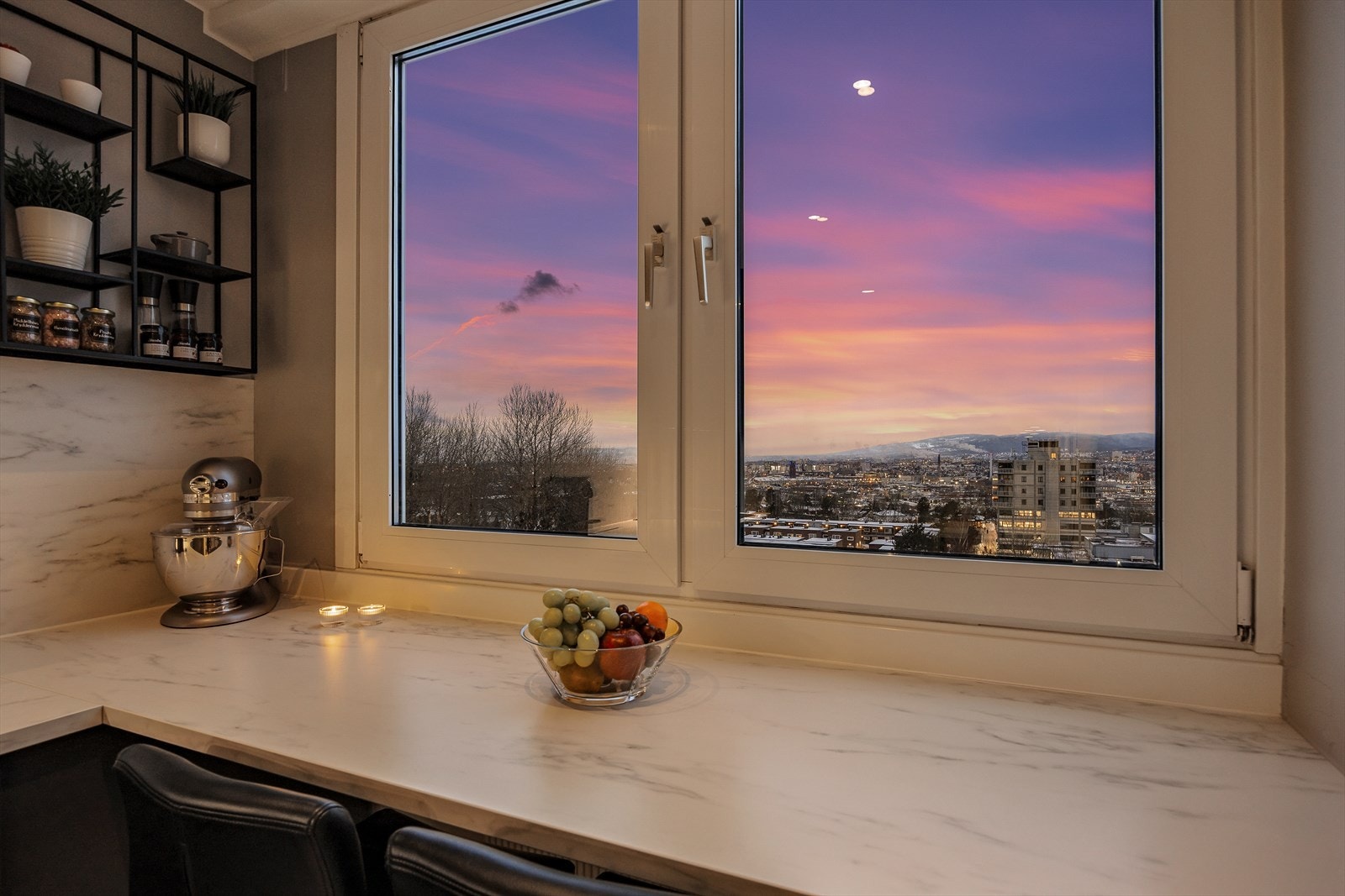 Kjøkkenvinduet rammer inn en fargerik kveldshimmel. Galleribilde