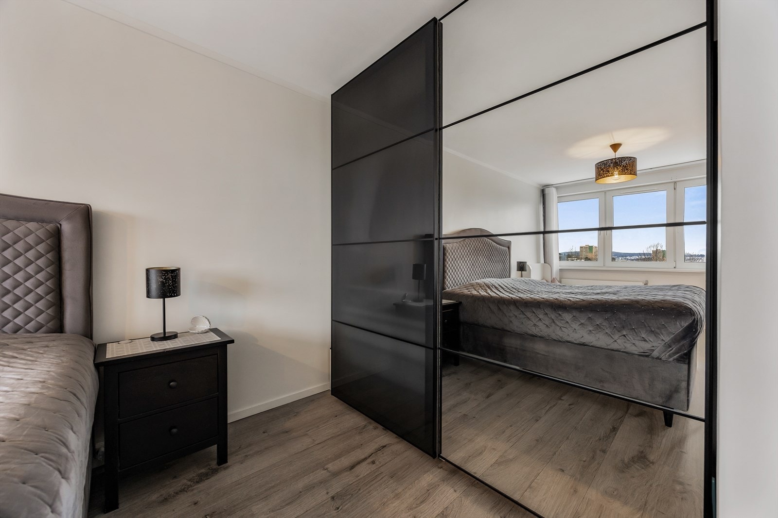 En stor skyvedørsgarderobe med speilfronter gir rikelig med oppbevaringsplass. Galleribilde