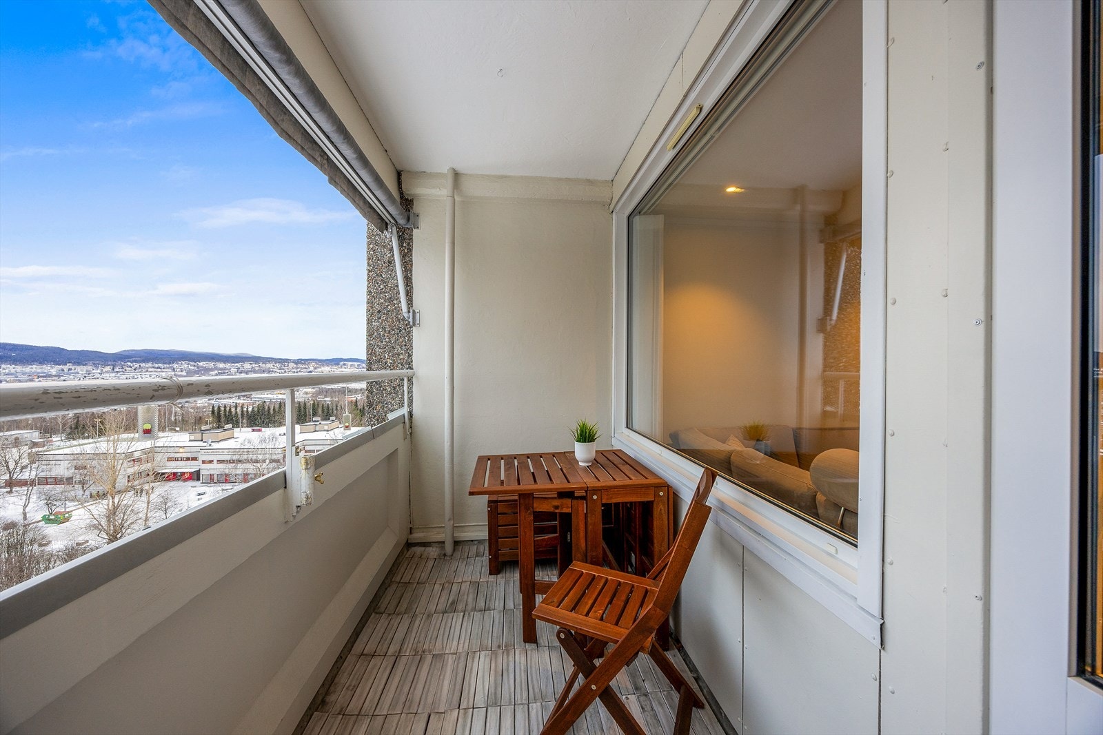 Balkongen har trefliser på gulvet og plass til en sittegruppe. Galleribilde