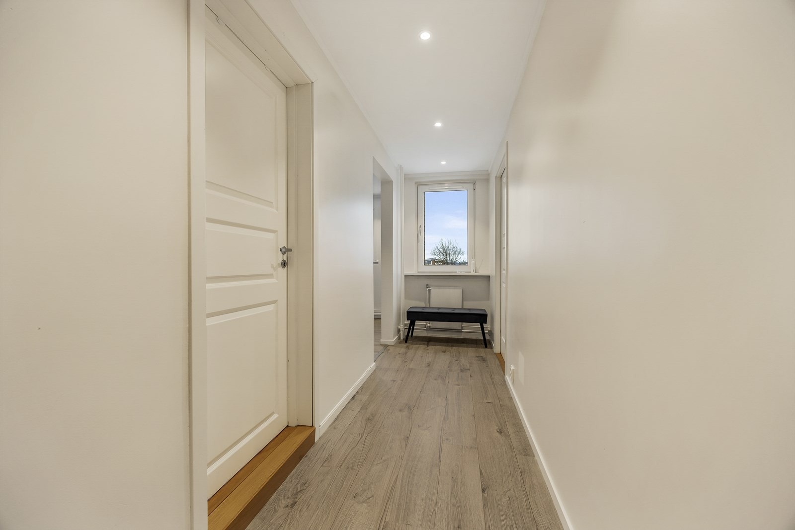 Gjennomgående laminatgulv og lyse veggflater skaper et helhetlig inntrykk. Galleribilde