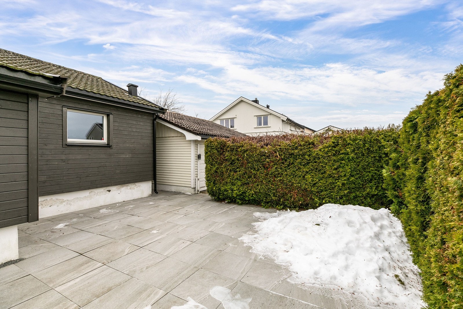 Foran inngangspartiet ble en omfangsrik og flislagt platting anlagt i 2022. Galleribilde