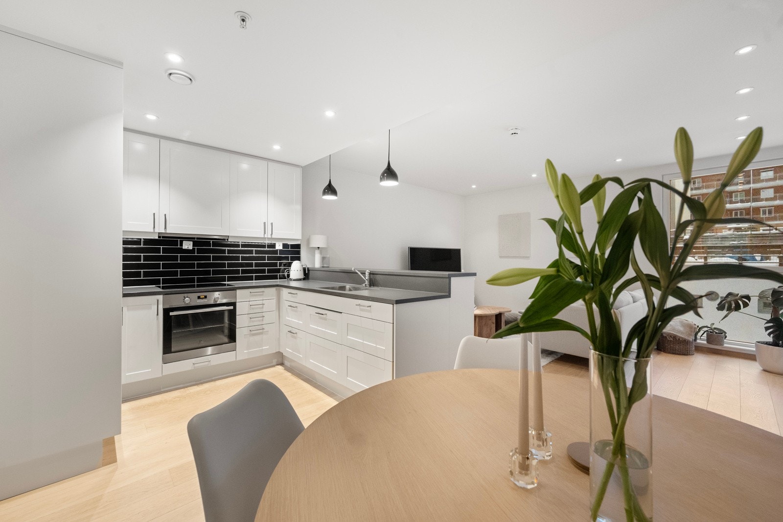 Lyst og pent kjøkken med plass til spisebord med stoler. Galleribilde