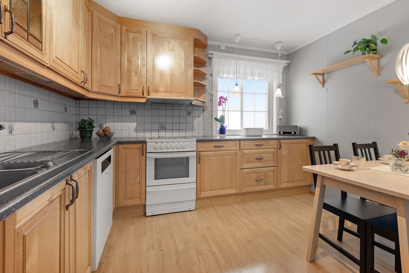 Ett meget romslig kjøkken med takhøye overskap, godt med benkeplass. Galleribilde