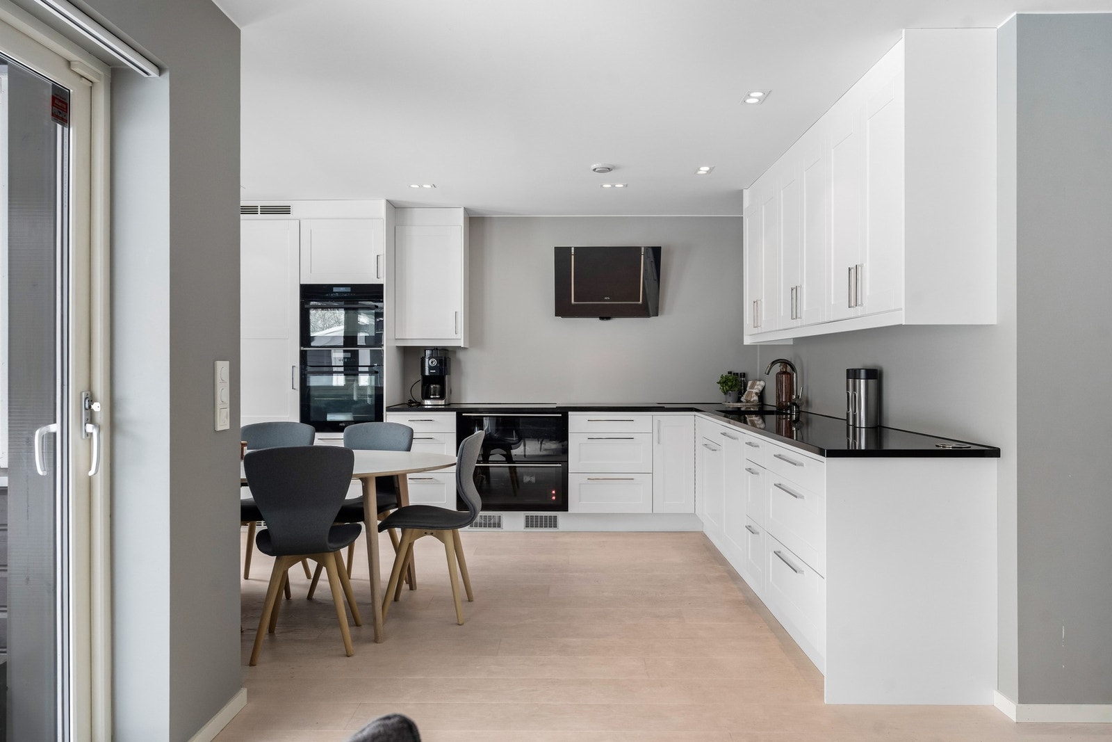 Elegant kjøkken med lekre profilerte fronter og en benkeplate av stein. Galleribilde