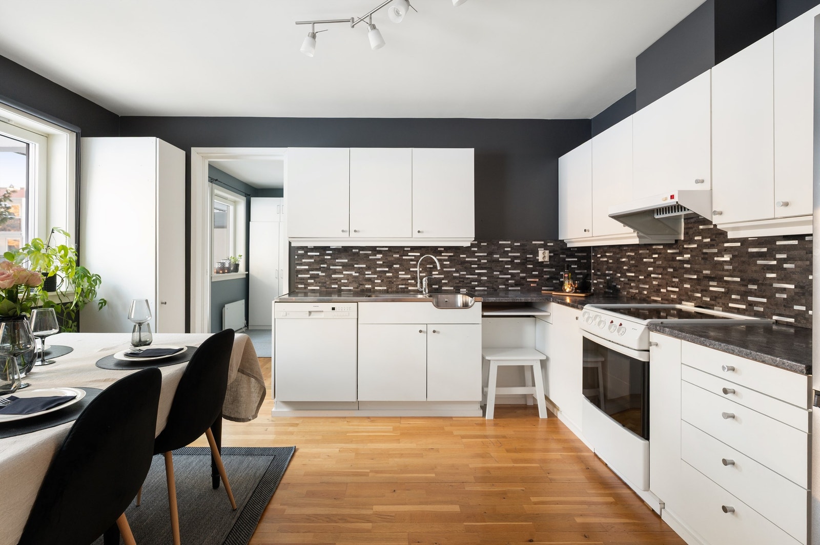 Kjøkkeninnredningen har glatte fronter, laminat benkeplate og kullfilterventilator. Galleribilde