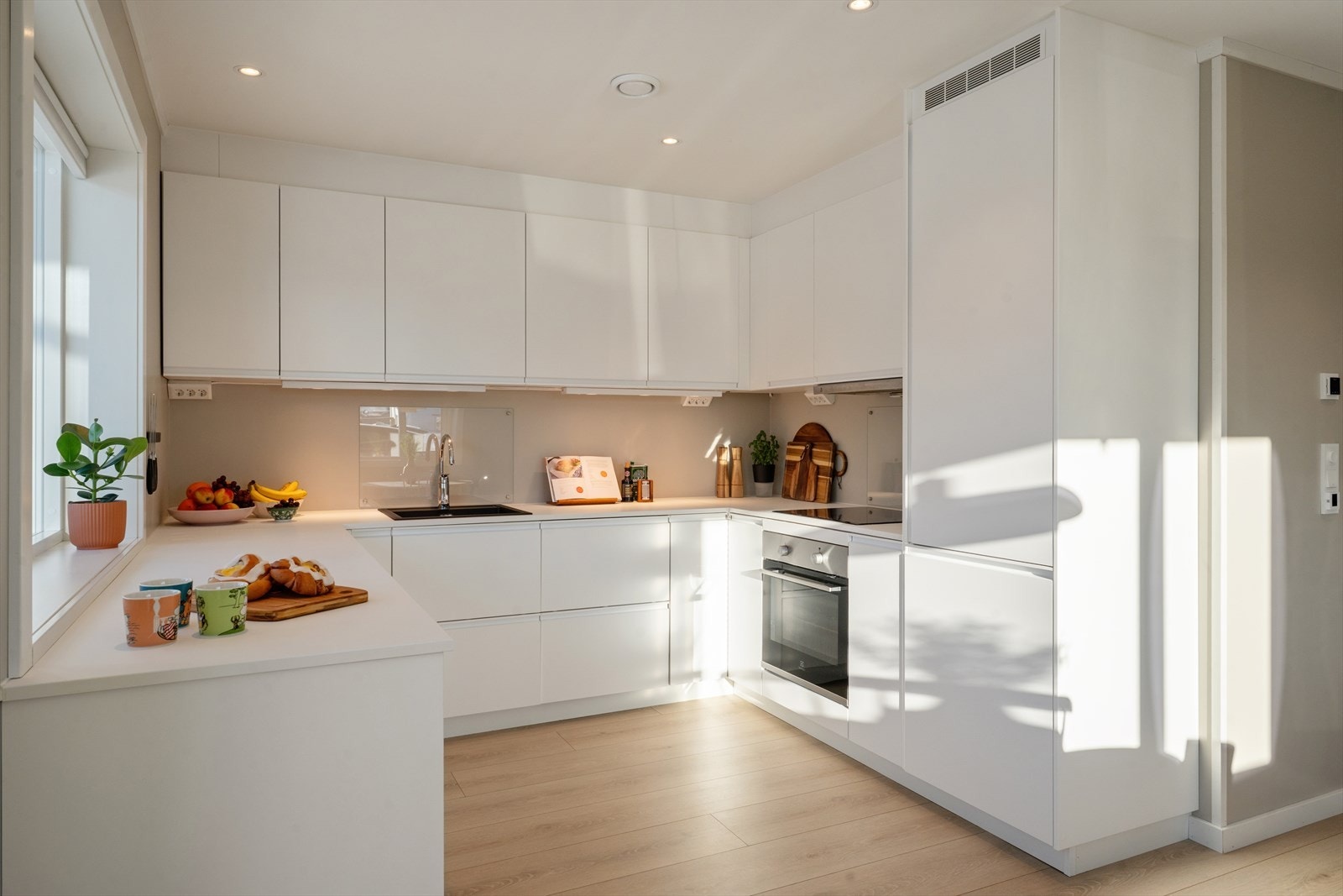 Moderne kjøkkeninnredning med glatte fronter og en laminert benkeplate som gir en praktisk arbeidsflate. Galleribilde