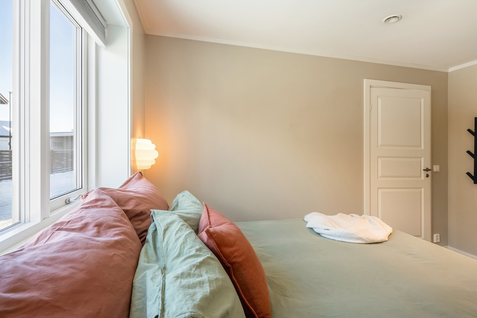 Malte vegger og laminatgulv gir en stilren finish til soverommet. Galleribilde