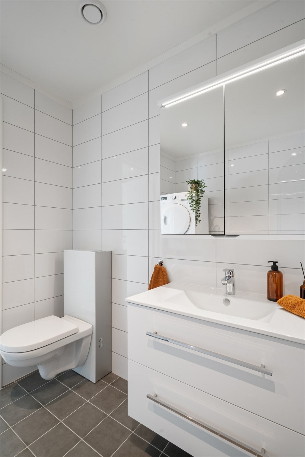 Innredet med badekar, baderomsinnredning med heldekkende servant og veggmontert toalett. Opplegg for vaskemaskin. Galleribilde