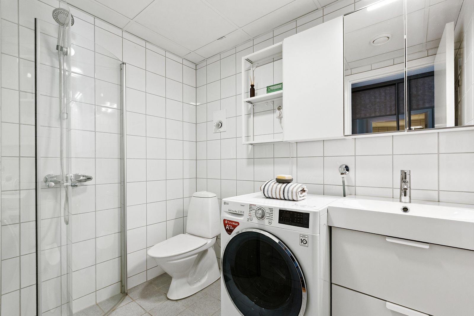 Flislagt bad med vaskemaskin. Galleribilde