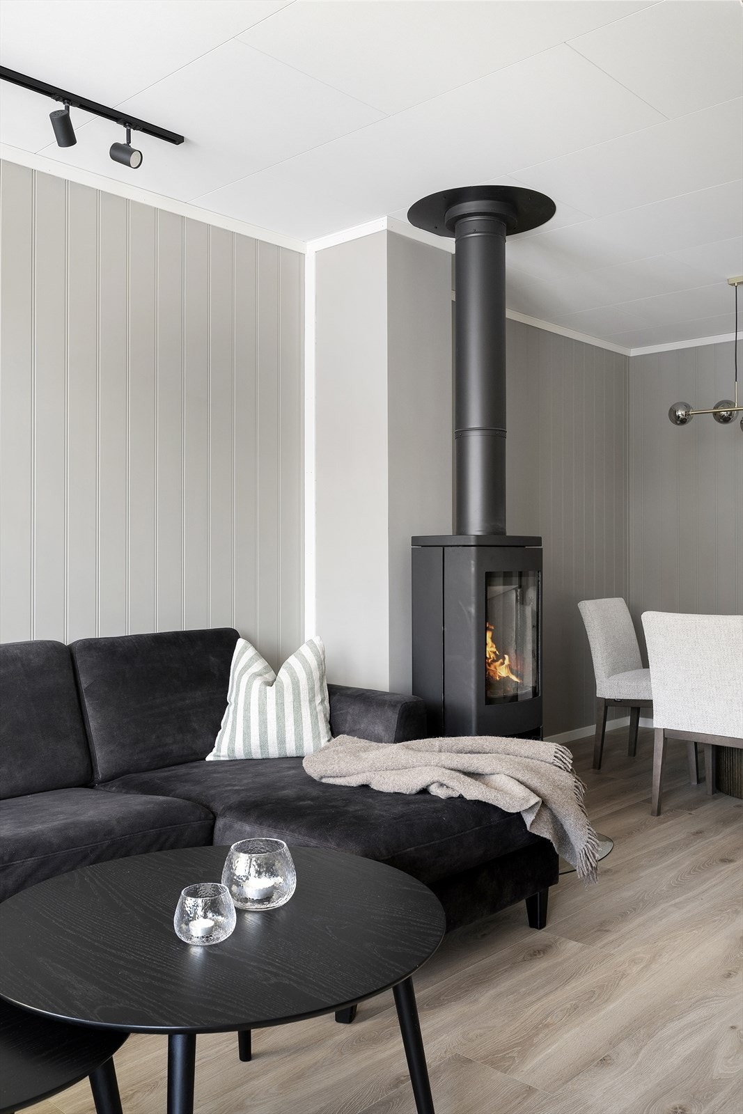 I midten av rommet står det en moderne peis som varmer godt i hele boligen Galleribilde