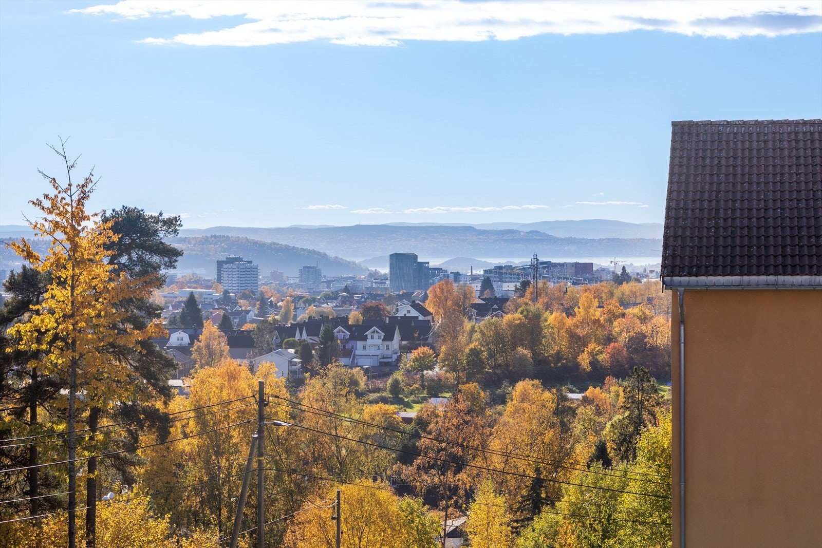 Vakker utsikt ned mot fjorden, omgitt av frodige grøntarealer. Galleribilde