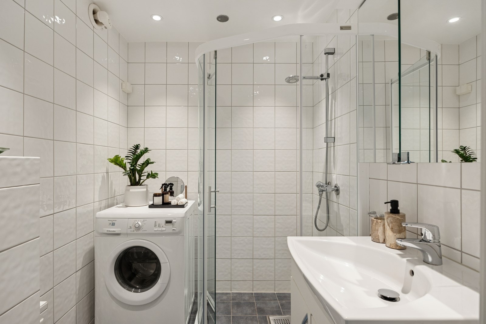 Baderommet ble oppgradert i 2019, og har tidløse fliser, lagring i speil- og servantskap samt en romslig dusjsone. Galleribilde