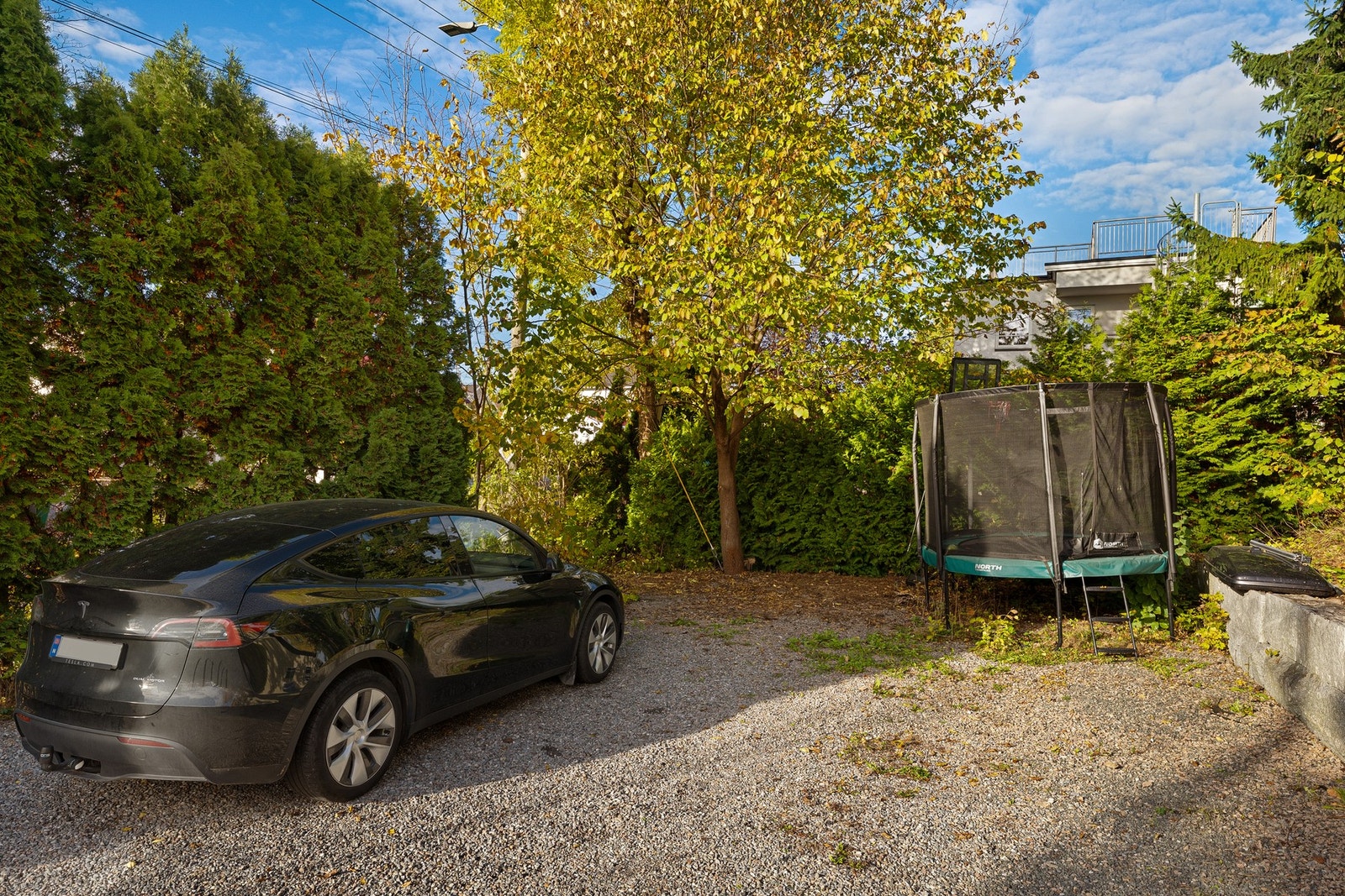 Romslig gårdsplass med to biloppstillingsplasser som disponeres av leiligheten. Galleribilde