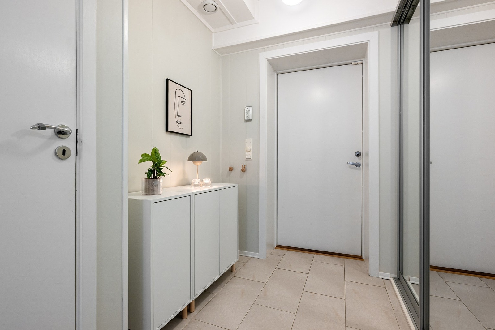 Innbydende entré med flislagt gulv og skyvedørsgarderobe installert av dagens eiere, som gir god oppbevaringsplass. Galleribilde