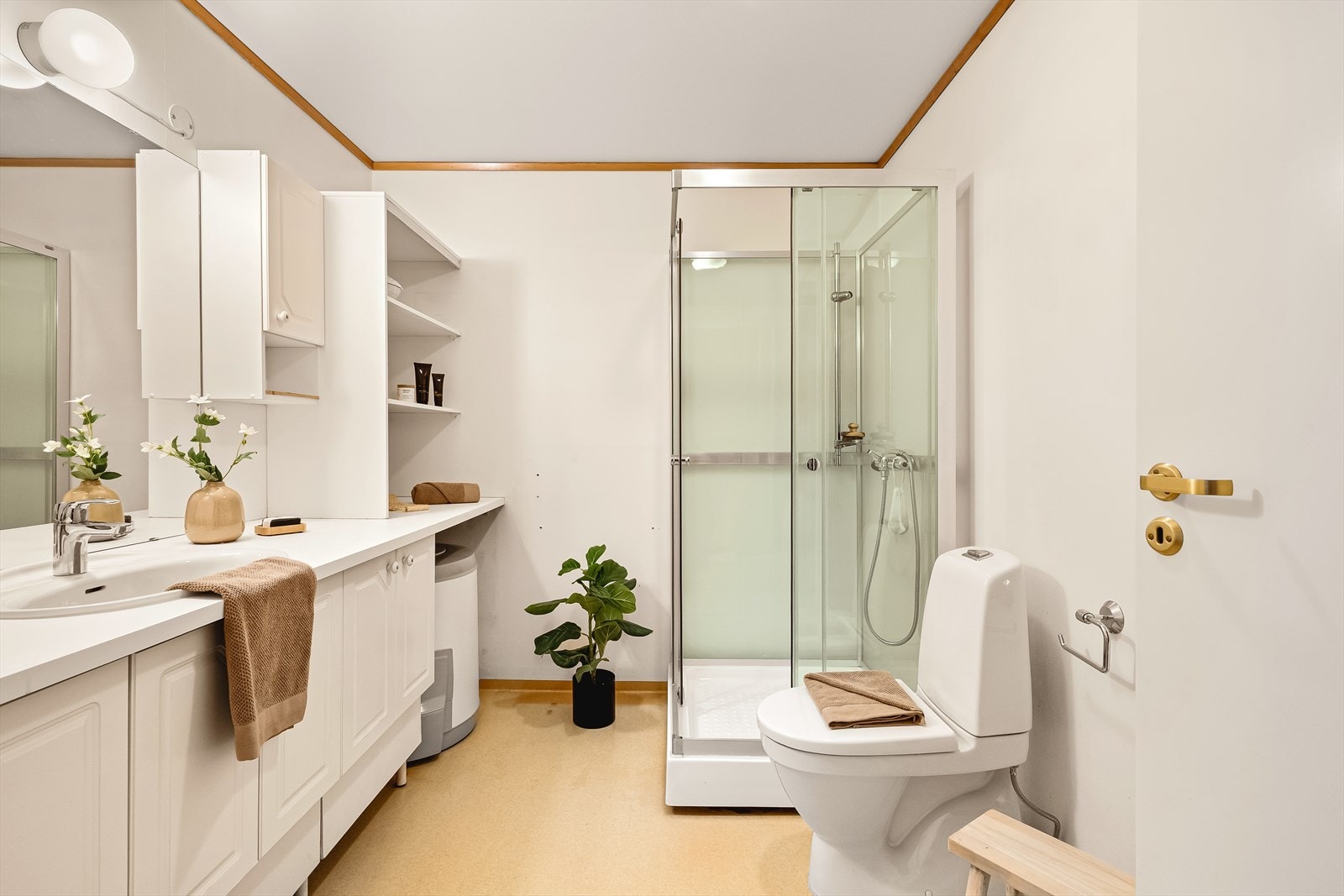 Langstrakt benkeplate over underskap, varmtvannsbereder og vaskemaskin. Nyere varmtvannsbereder og dusjkabinett. Galleribilde