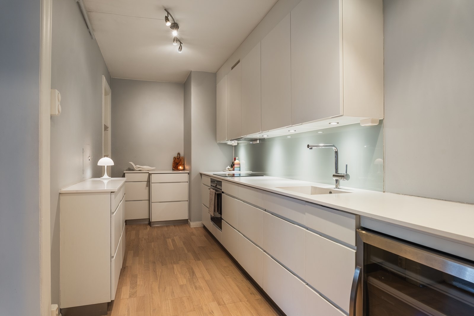 Kjøkkenet er et moderne Kvik-kjøkken fra 2017 med hvite, glatte fronter på skuffer og skap. Galleribilde