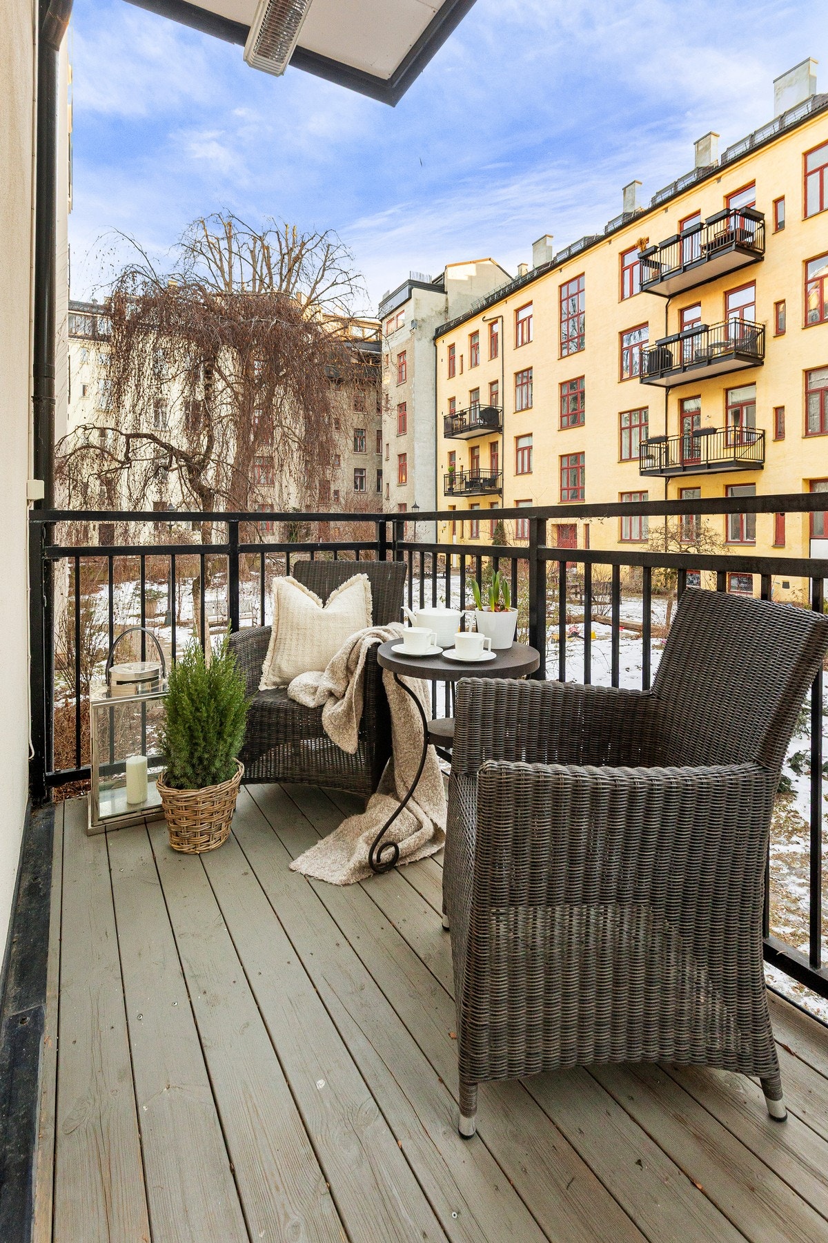 Pent utformet balkong med terrassegulv og stålgelender, som vender ut mot stor, grønn og stille bakgård Galleribilde