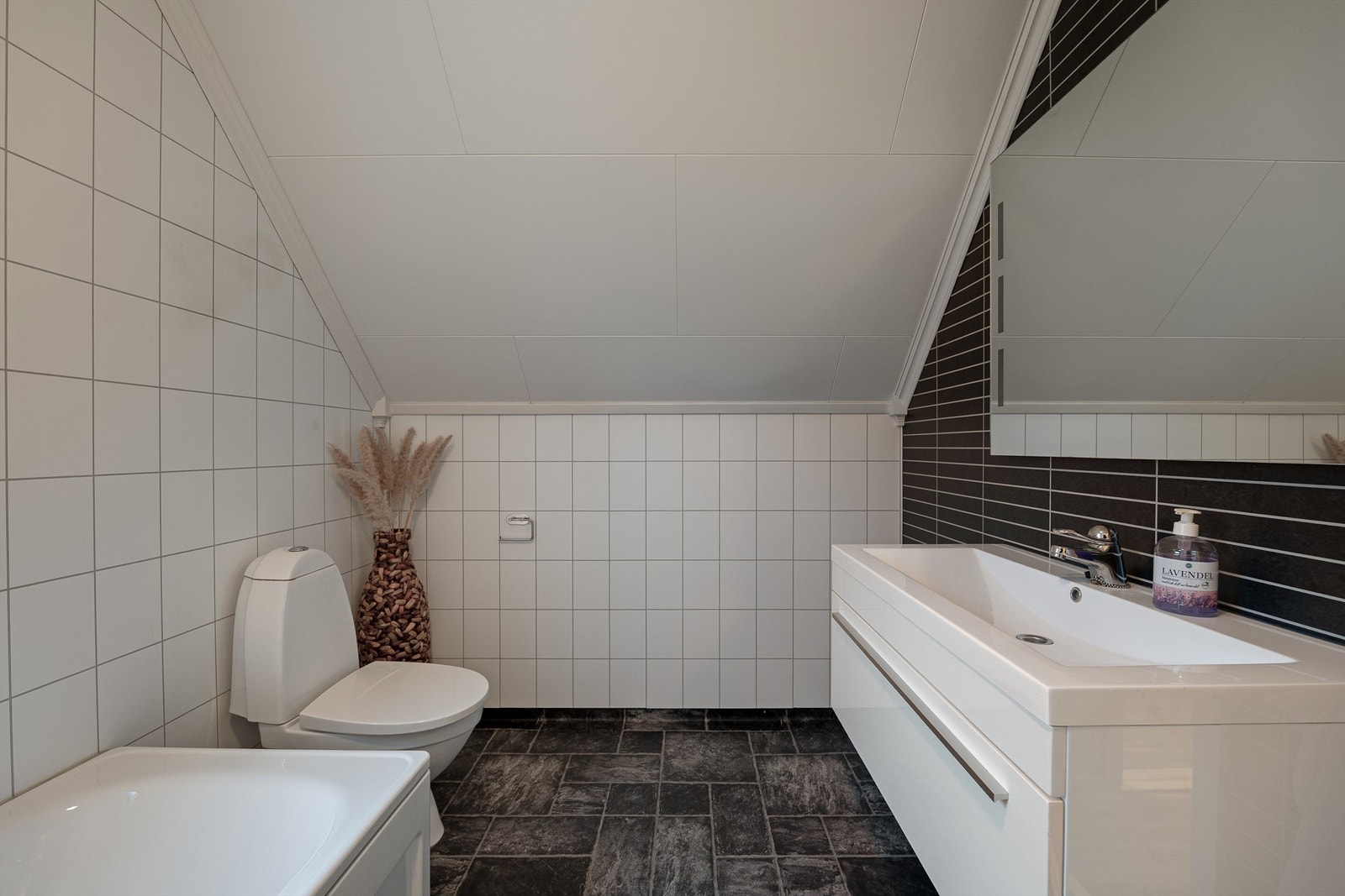 Badets gulv og vegger er utført med henholdsvis vinylbelegg og våtromsplater. I gulvet er det også elektrisk varme. Galleribilde