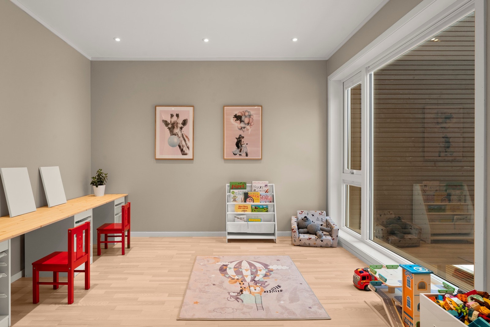 Stue med vindu fra tak til gulv som gir mye lys - fleksibelt rom som i dag er brukt som lekeområde. Galleribilde