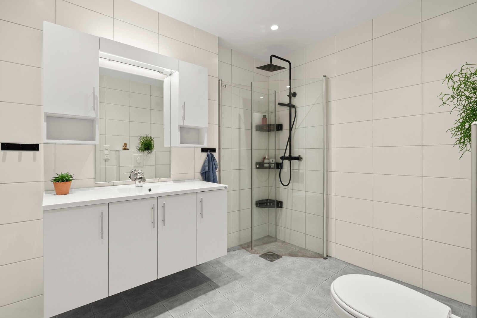 Baderommet har innredning med nedfelt servant, veggmontert toalett og dusjvegger/hjørne. Galleribilde
