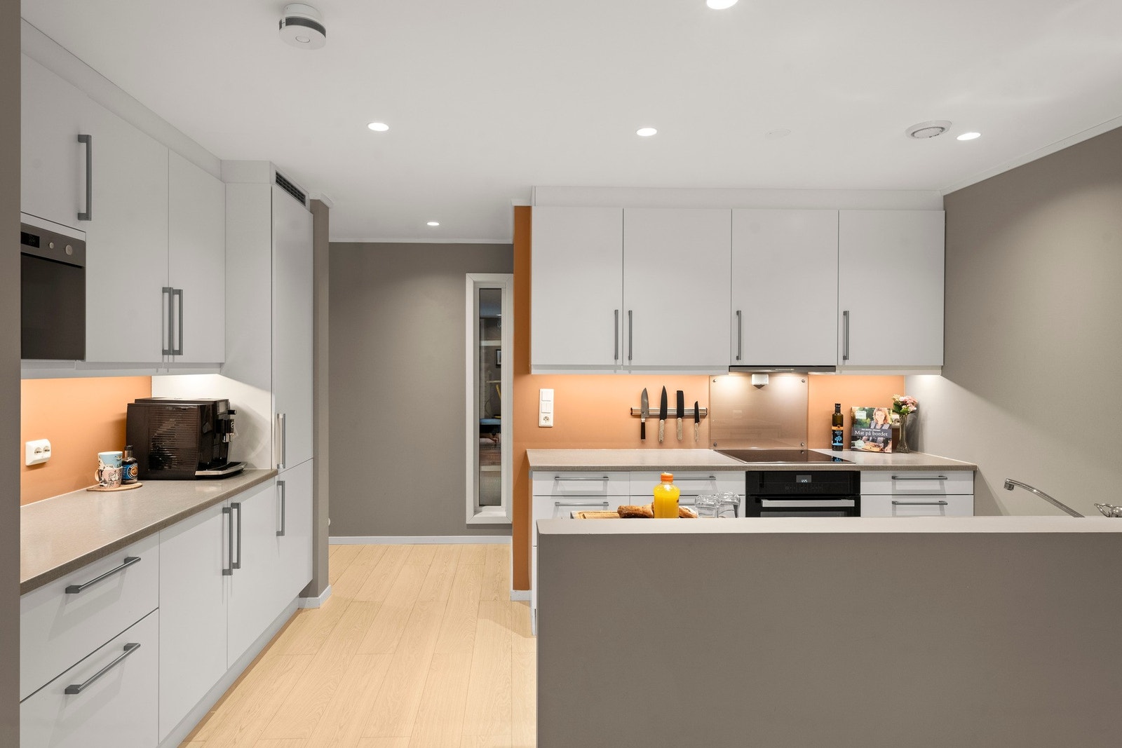 Kjøkkenet har innredning med glatte fronter. Benkeplaten er av laminat. Det er kjøl/fryseskap, oppvaskmaskin, komfyr, induksjonstopp, micro, vannstoppsystem og komfyrvakt. Galleribilde