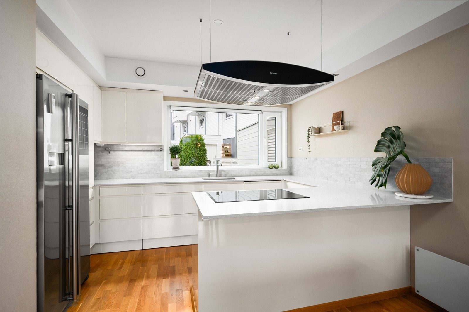 Lys og delikat innredning med benkeplate i sten og flisfelt over benk Galleribilde