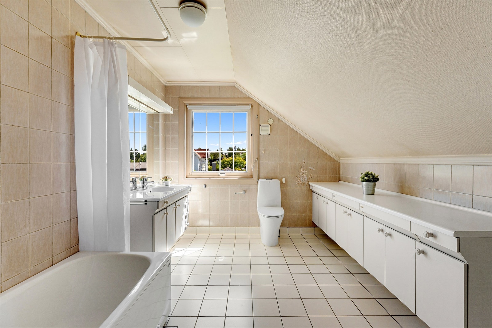 Stort og flislagt baderom med gulvvarme. Nyere servant og toalett Galleribilde