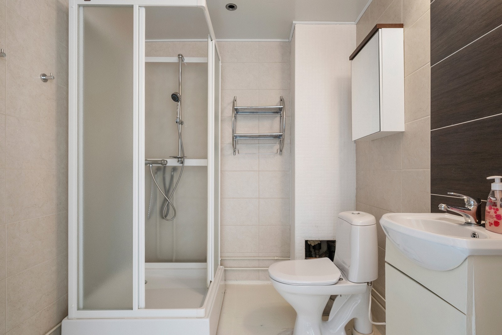 Baderom med malt/behandlet betonggulv (terrasso/epoxy), flislagte vegger og malt himling. Opplegg for vaskemaskin. Galleribilde