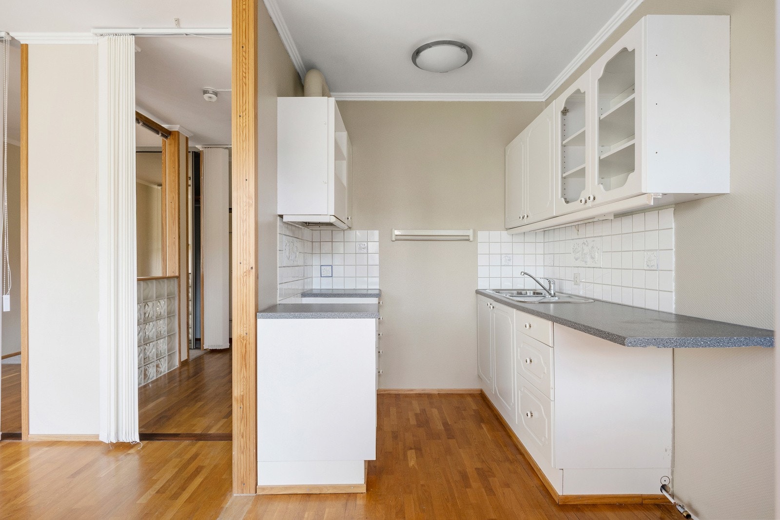 Kjøkken i egen sone med innredning langs to vegger. Galleribilde