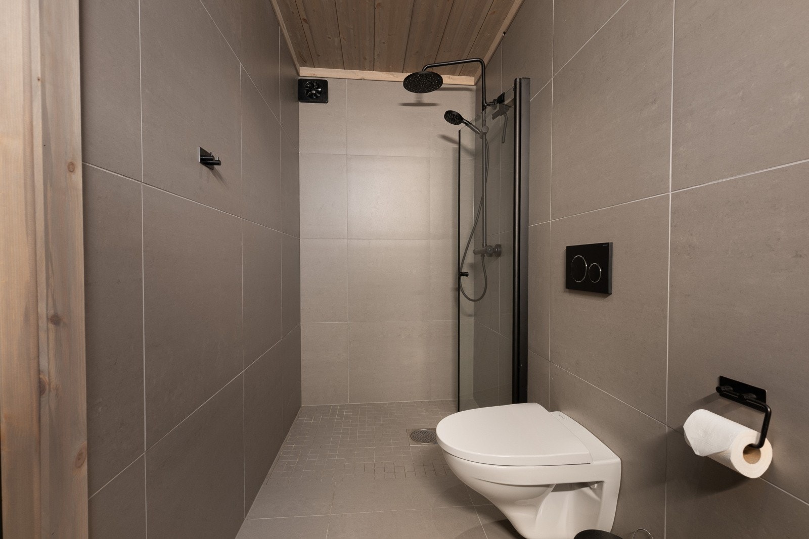 Badet er utstyrt med innredning med nedfelt servant, veggmontert toalett og dusjvegger/hjørne. Galleribilde