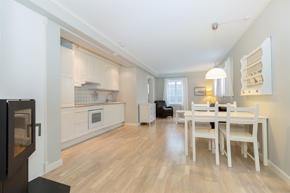 Lys og luftig stue med åpen kjøkkenløsning - her er det god plass til både sofagruppe, spisebord og annet møblement. Den åpne planløsningen gir en sosial og funksjonell atmosfære. Galleribilde