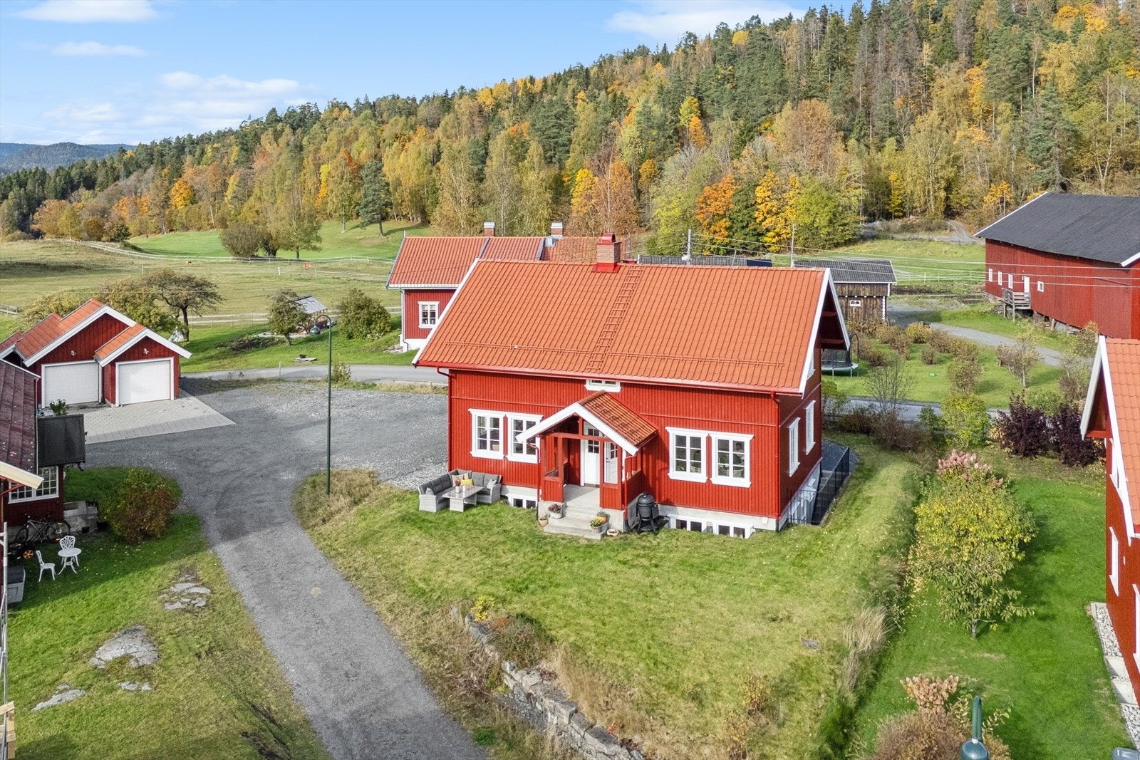 Tomten er åpen og lys, med en lettstelt hage opparbeidet med gressplen og noe beplantning. Galleribilde