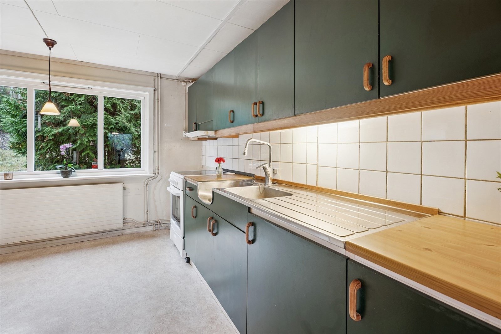 Innredningen har flislagt vegg over benken og belysning under overskapene. Galleribilde