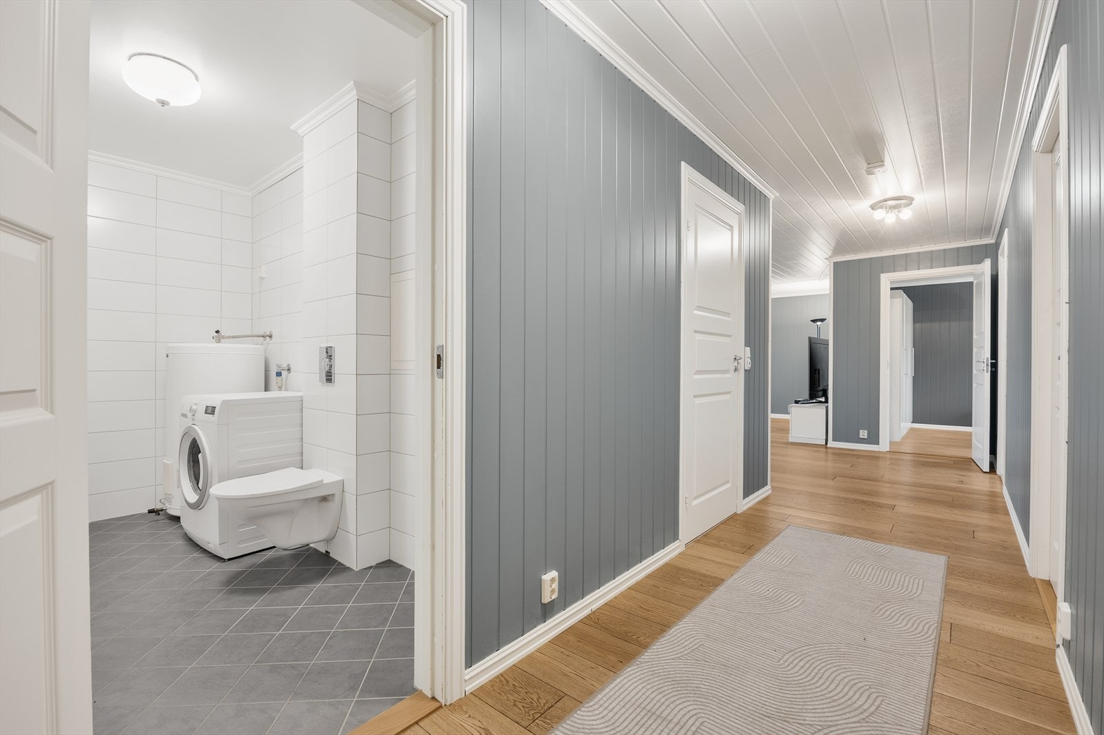 Fra gangen er det inngang til hovedbadet, som også fungerer som vaskerom med opplegg for vaskemaskin. Galleribilde