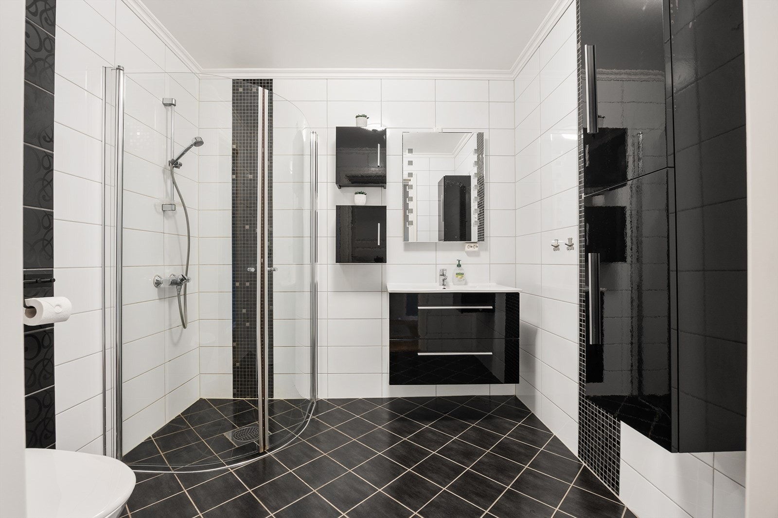 Det andre badet er også helfliset, med servantinnredning, veggskap og dusjhjørne. Galleribilde