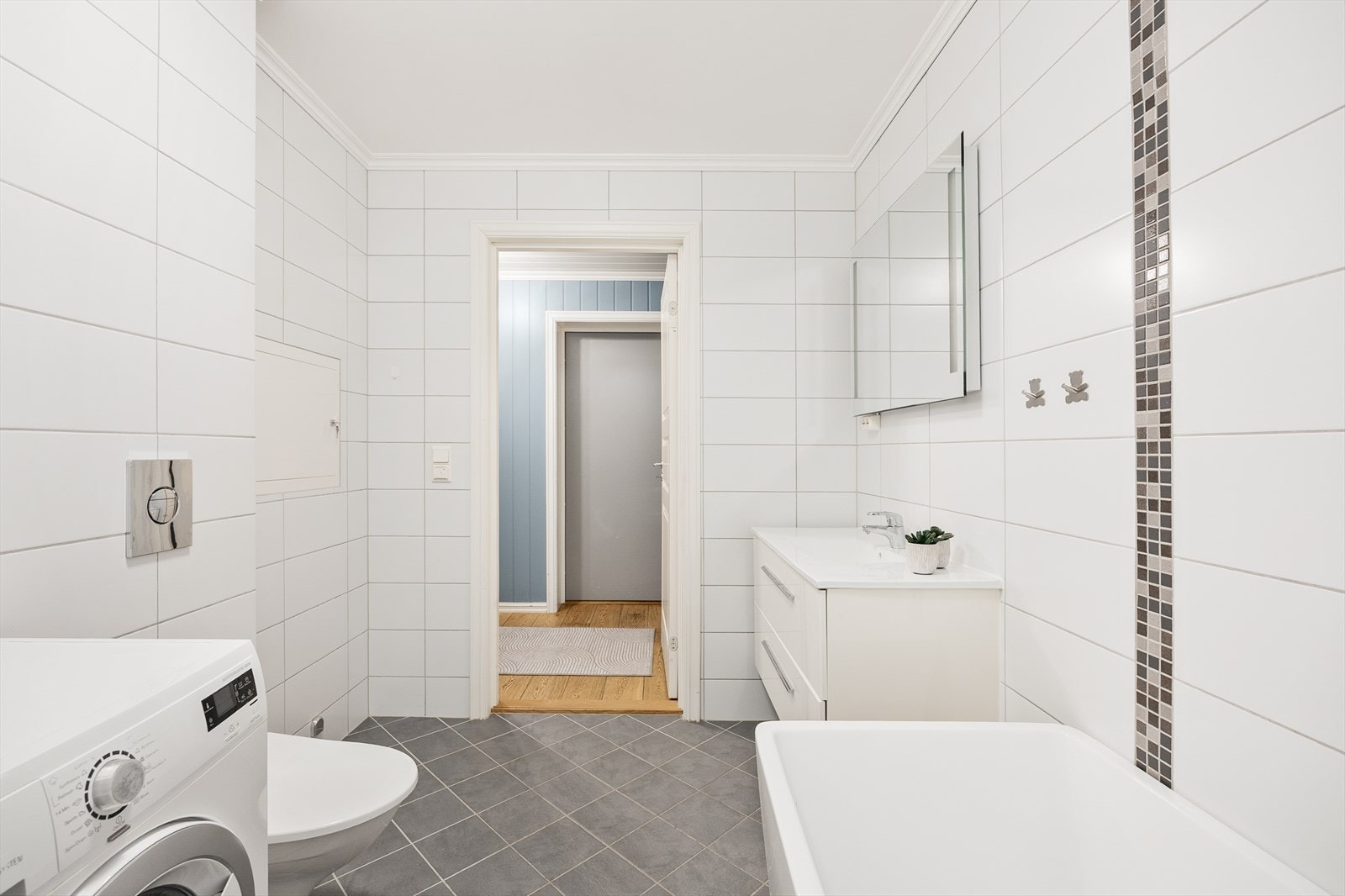 Hovedbadet er romslig og utstyrt med badekar, servant med underskuffer og vegghengt toalett. Galleribilde