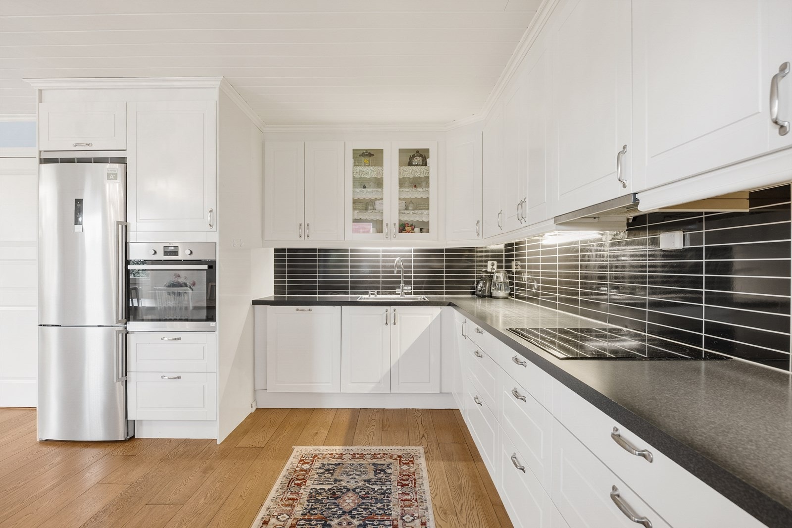 Her er det godt med både skap- og benkeplass, med hvite profilerte fronter og laminat benkeplate. Galleribilde