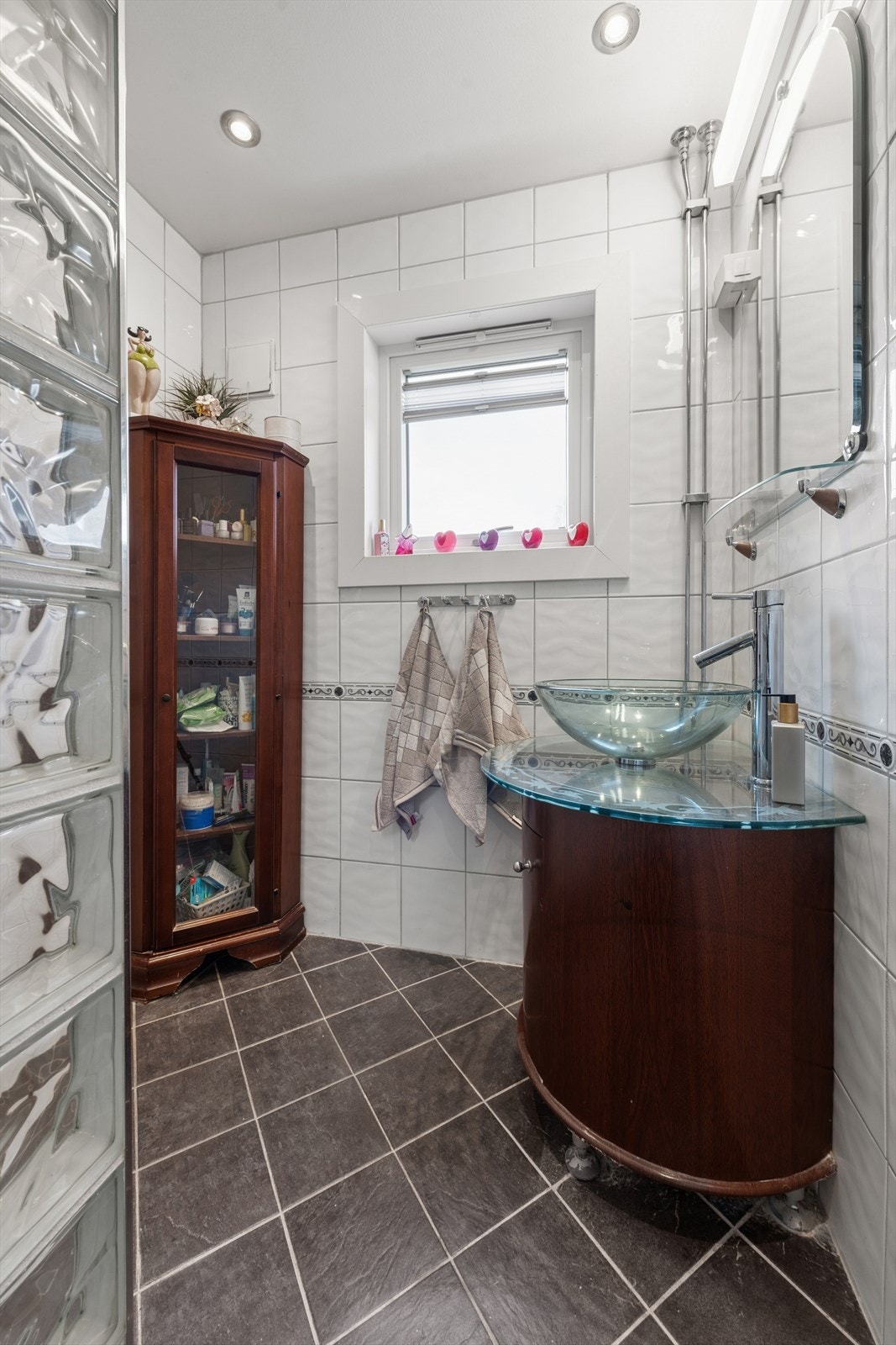 Baderom med fliser på gulv og vegger, samt malt tak. Galleribilde