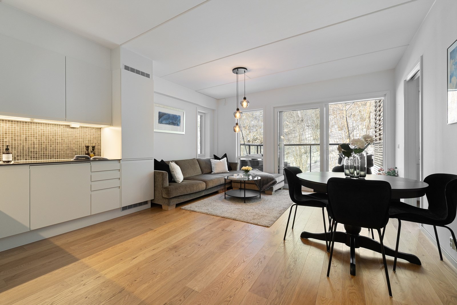 Lys og innbydende stue i åpen løsning mot kjøkken, gjør rommet til et lyst og sosialt allrom Galleribilde