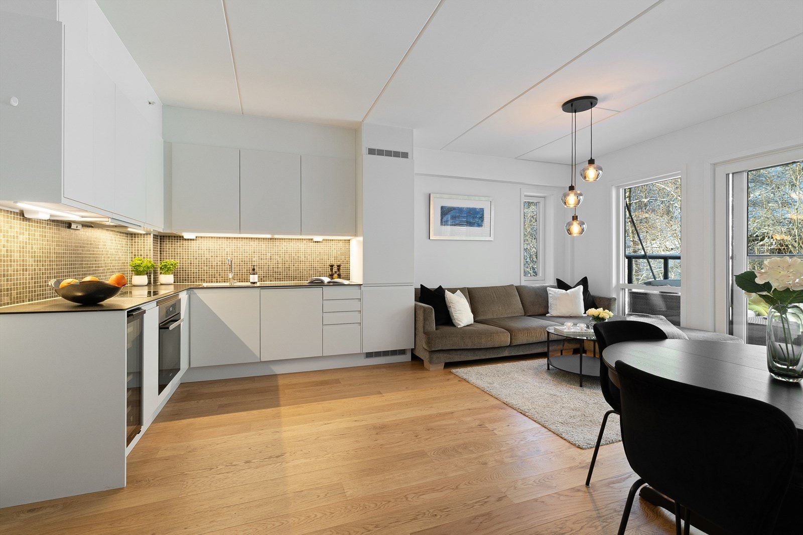 Moderne kjøkken fra kvalitetsleverandøren Sigdal harmonerer godt med resten av rommet. Kjøkkenet har bla. integrert vinskap, kjøl/frys og oppvaskmaskin. Galleribilde