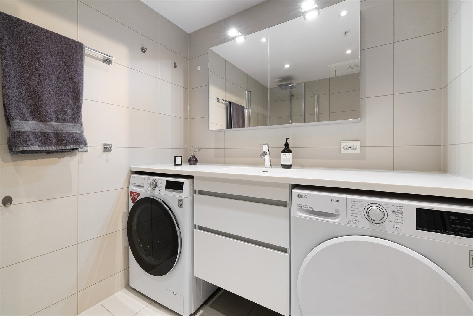 Rommet er innredet med vegghengt toalett, skuffeseksjon med hvite fronter, benkeplate og speilskap. Galleribilde