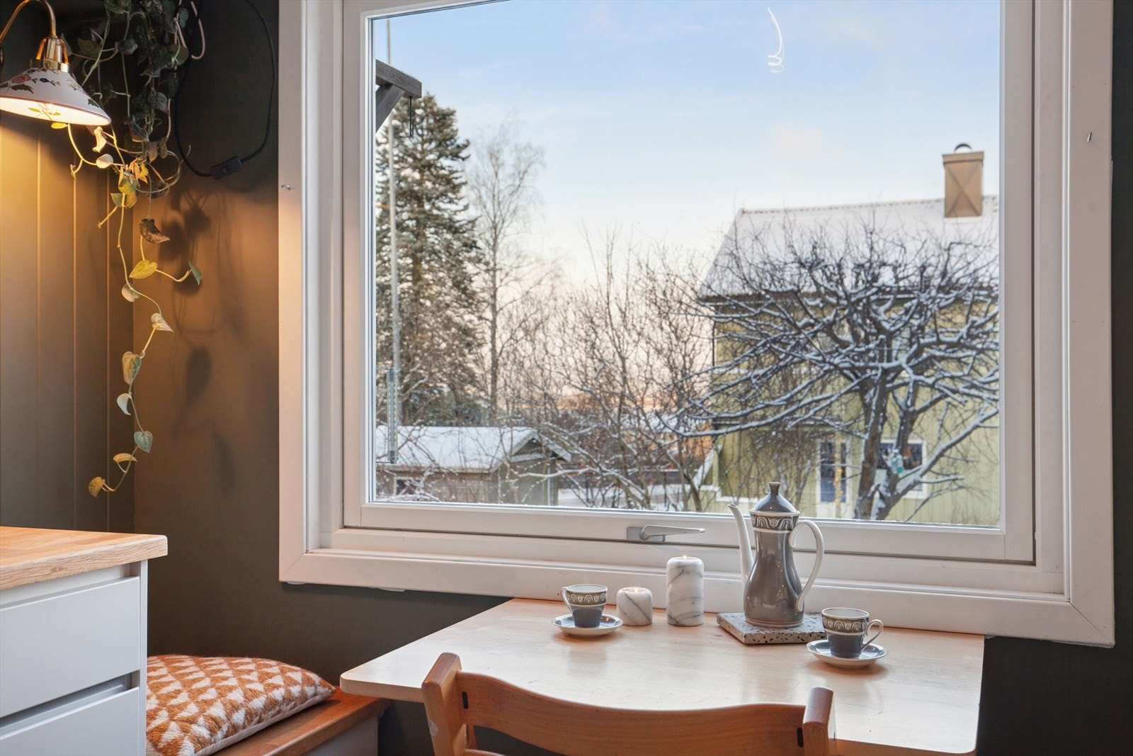 Fin detalj med sittebenker av innredning på begge sider av kjøkkenbordet. Galleribilde