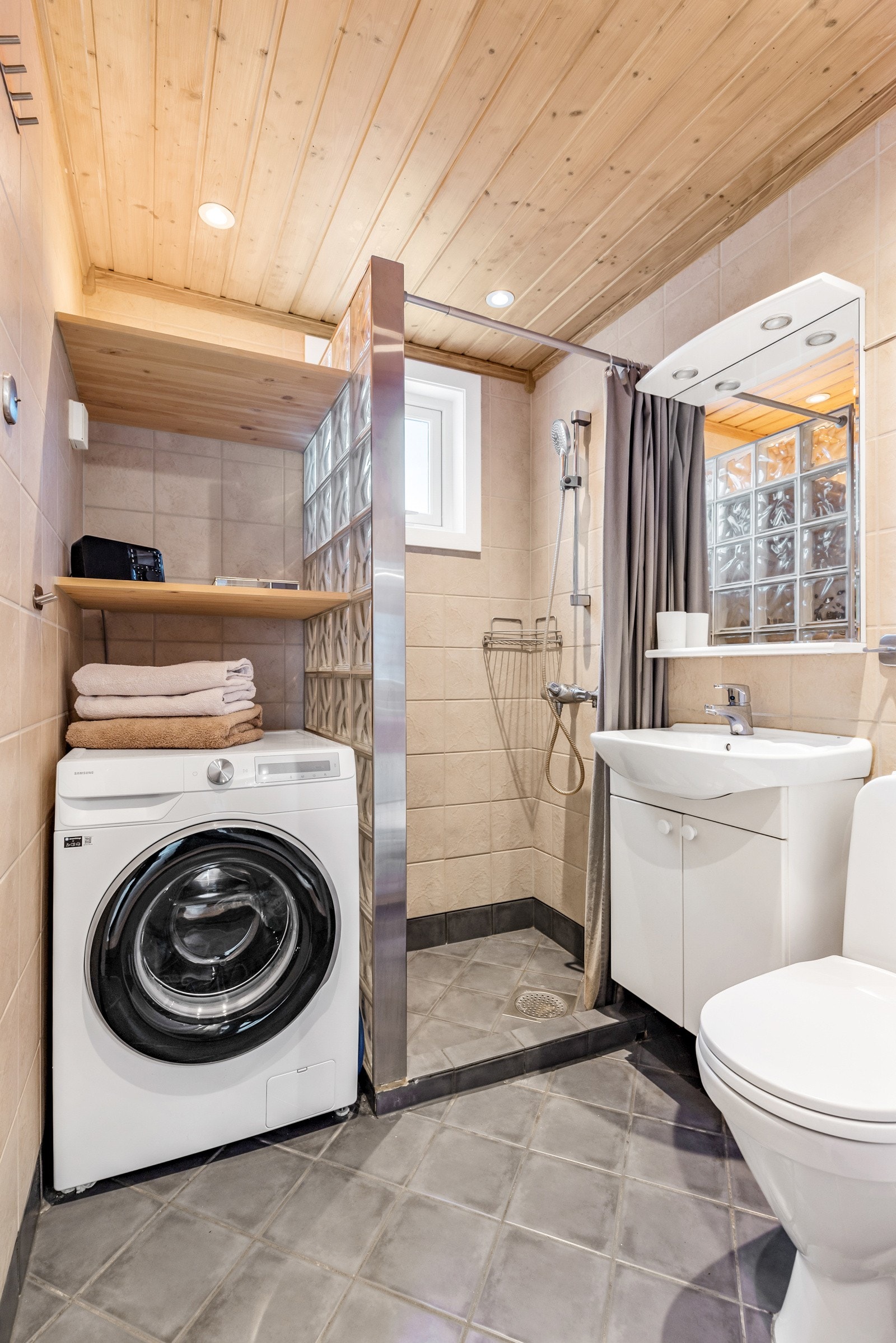 Flislagt bad med downlights, gulvvarme og opplegg for vaskemaskin. Galleribilde