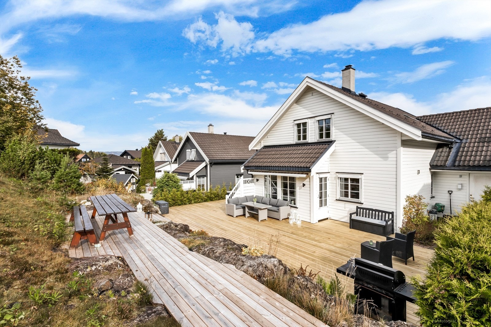 Stor og skjermet terrasse bygget etter terrenget som grenser til friareal. Galleribilde