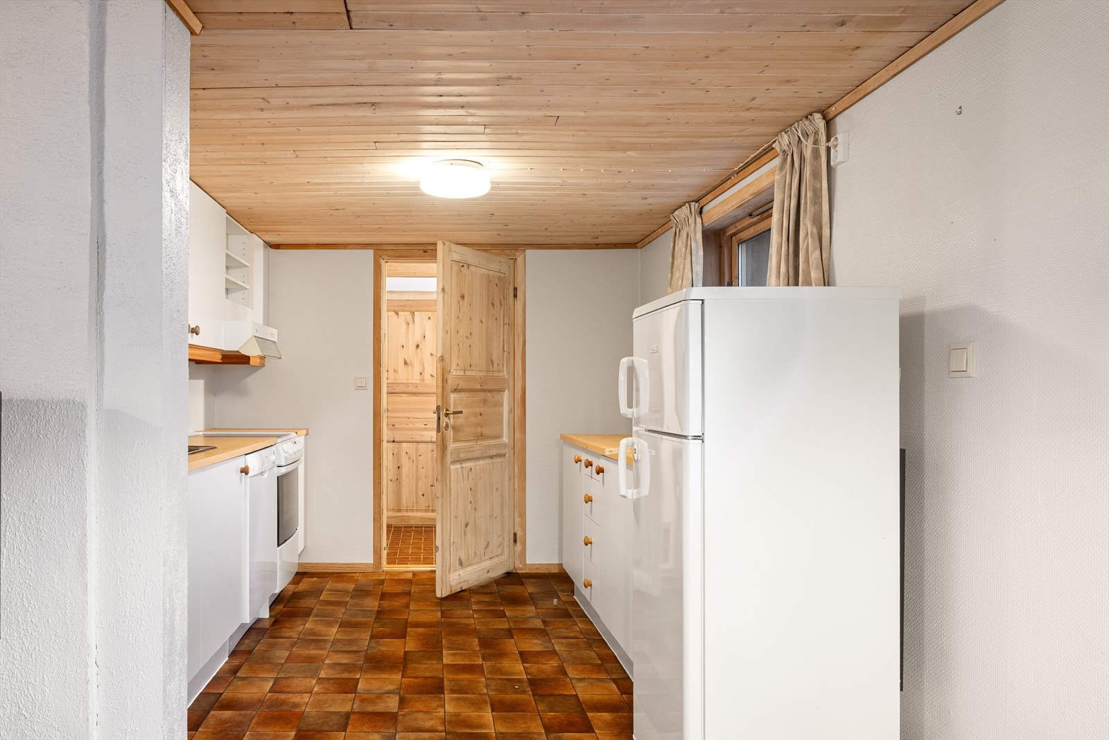 Kjøkkenet har innredning med hvite, glatte fronter og benkeplaten av laminat. Kjøkkenet har godt med skap- og benkeplass. Galleribilde