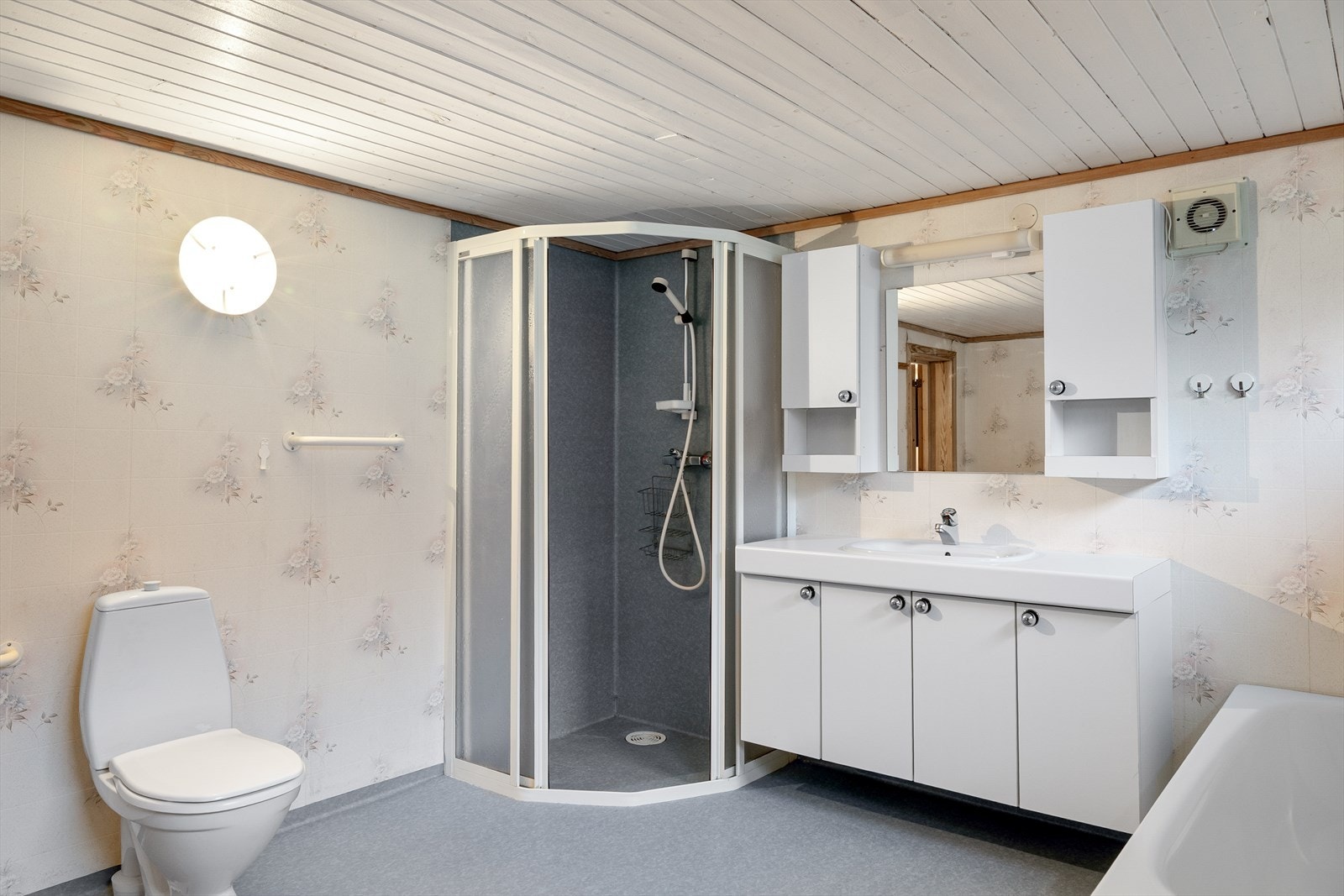 Badet er innredet med toalett, servant i møbel og dusjhjørne. Galleribilde