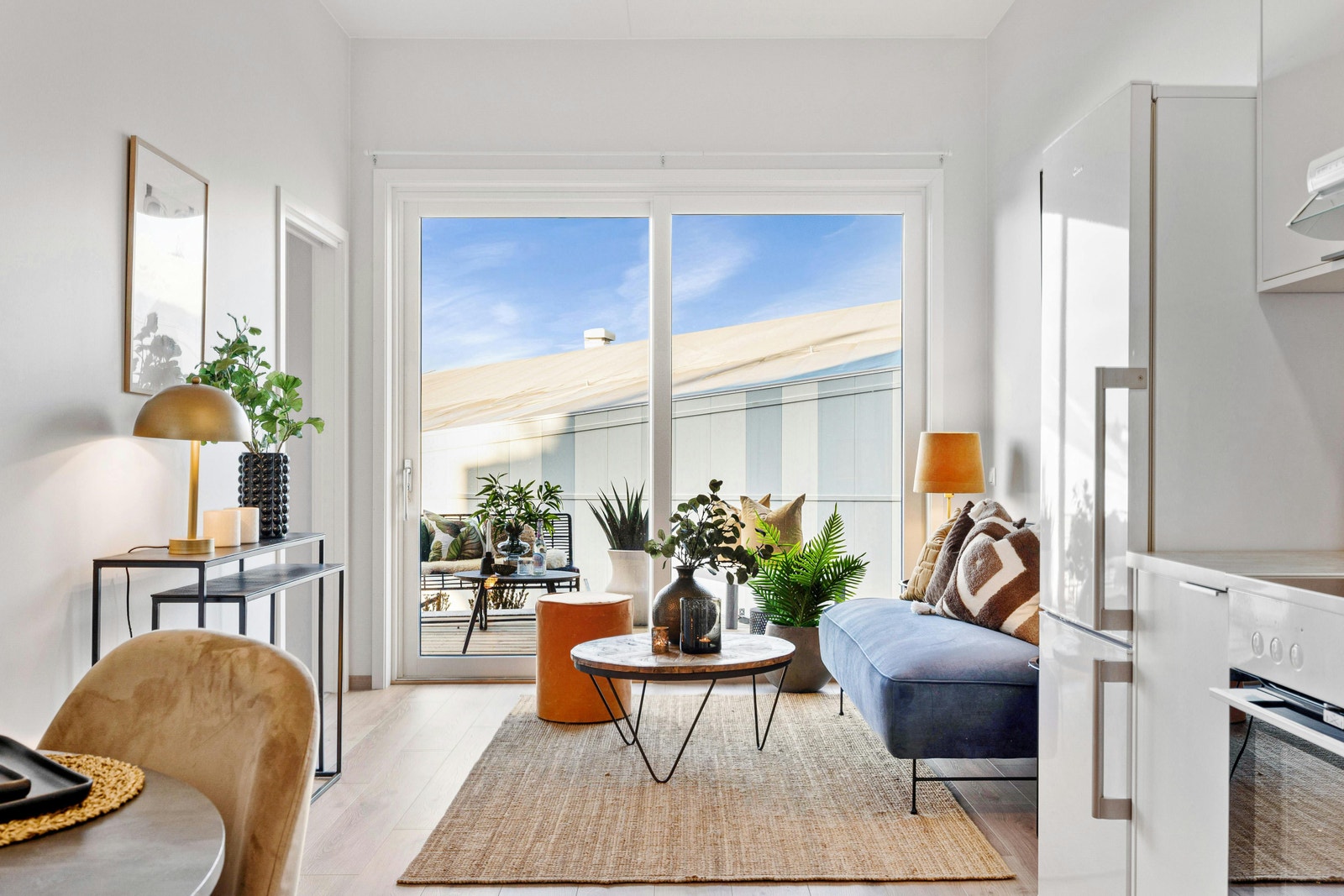 Stue med utgang til balkong i hyggelig omgivelser og morgen/formiddagssol Galleribilde