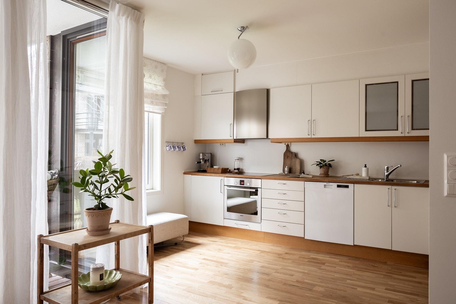 Pent og tidløst kjøkken med integrerte hvitevarer og frittstående kjøleskap og oppvaskmaskin. Galleribilde