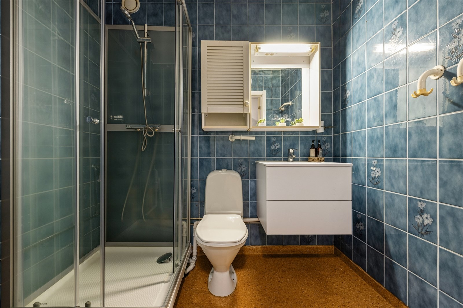 Baderom av god størrelse, utstyrt med servant med glatte fronter, gulvstående toalett og dusjkabinett. Galleribilde