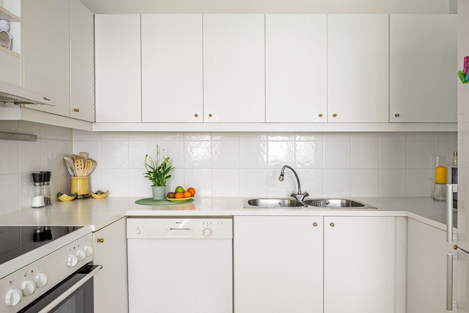 Praktisk med lyse fliser i benkeryggen og kjøkkenventilator med avtrekk ut. På kjøkkenet er det frittstående hvitevarer som komfyr, oppvaskmaskin og kjøleskap med frysedel som medfølger i handelen. Galleribilde